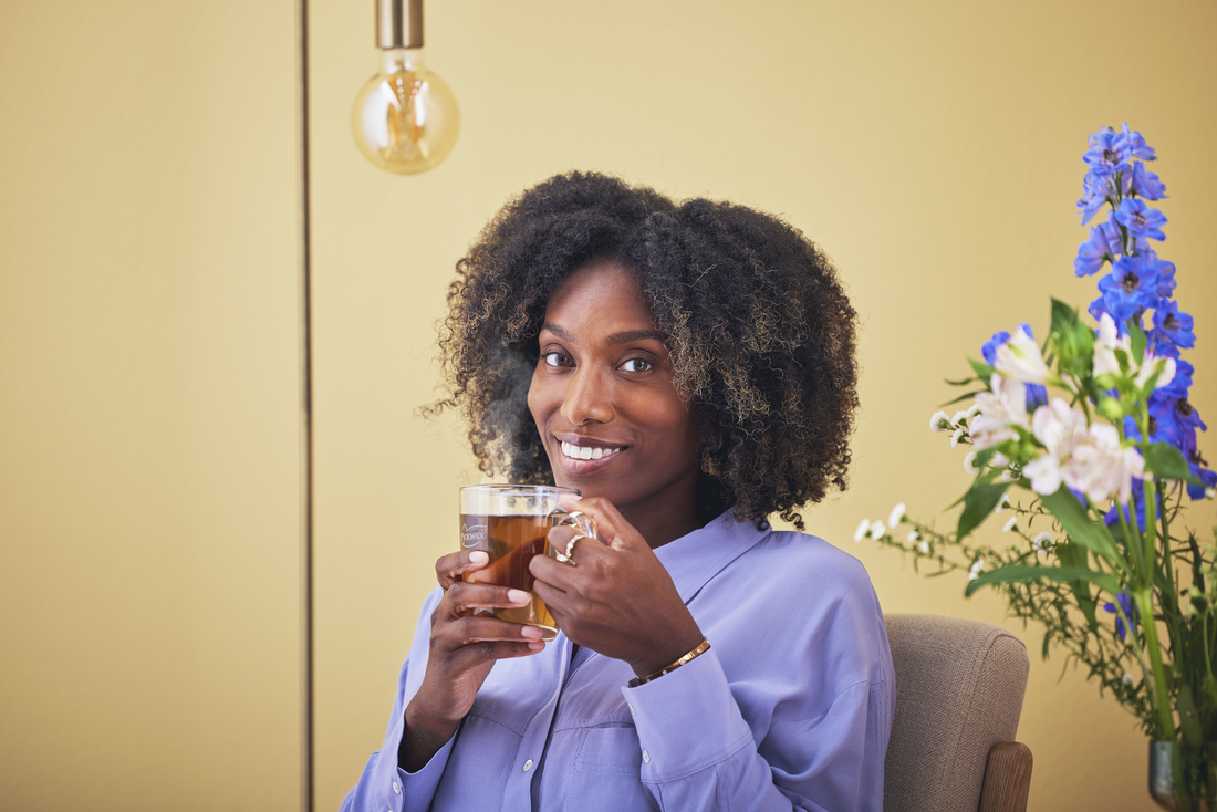 una mujer disfrutando de una taza de té pickwick
