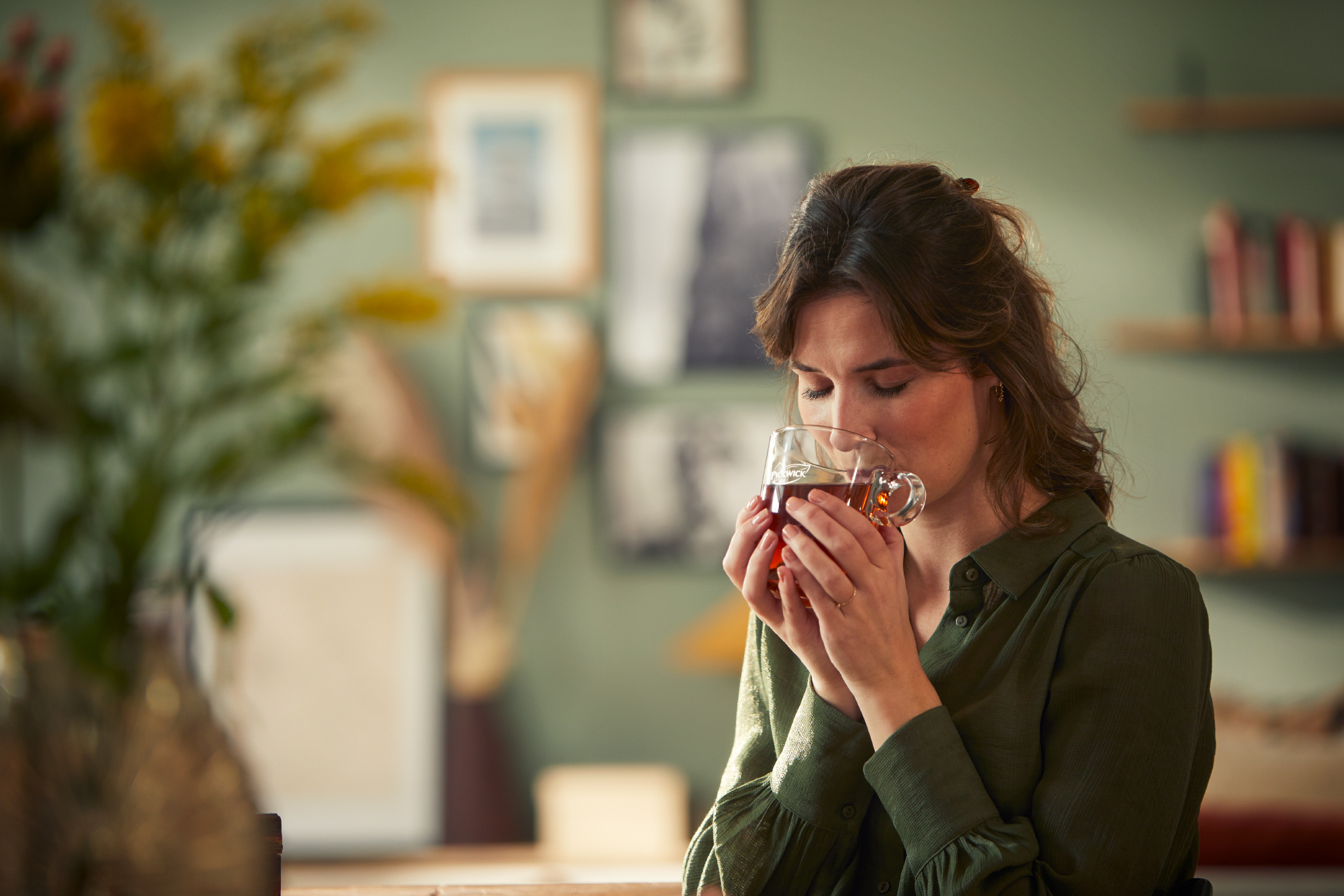 una mujer disfrutando de una taza de té pickwick
